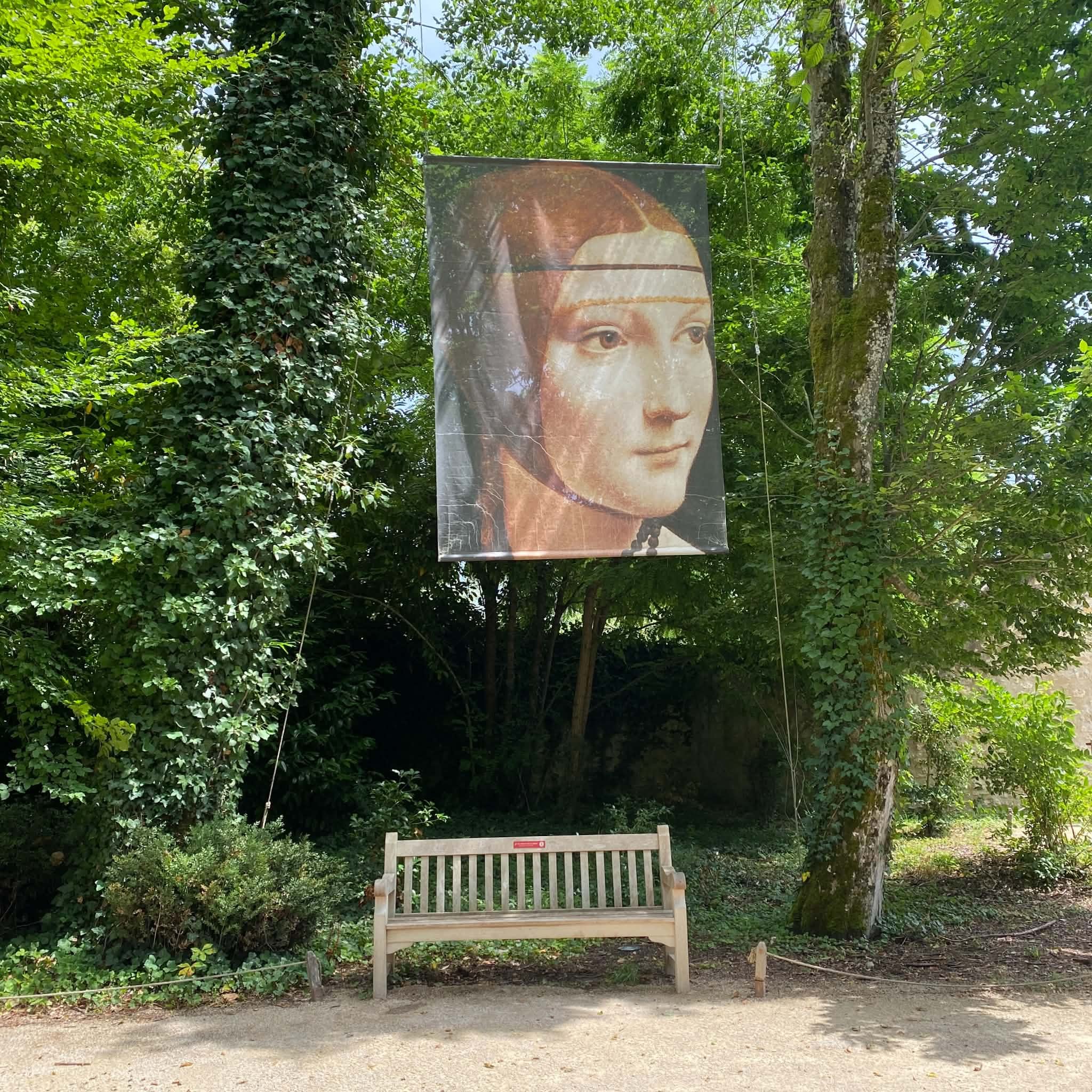 Reproduction d'un portrait de Léonard de Vinci suspendue dans le jardin du Clos Lucé, au-dessus d'un banc